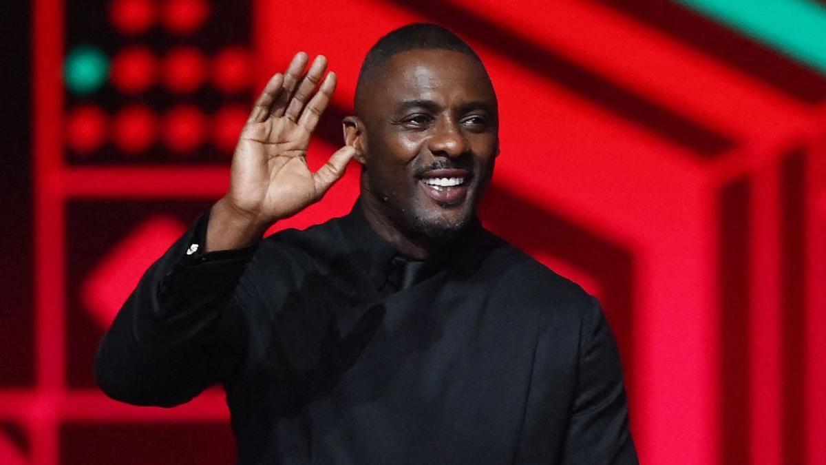 (L to R) English actor Idris Elba and British-Bangladeshi sports journalist broadcaster Reshmin Chowdhury walk on stage during the draw for the 2022 World Cup in Qatar at the Doha Exhibition and Convention Center on April 1, 2022. (Photo by FRANCK FIFE / AFP)