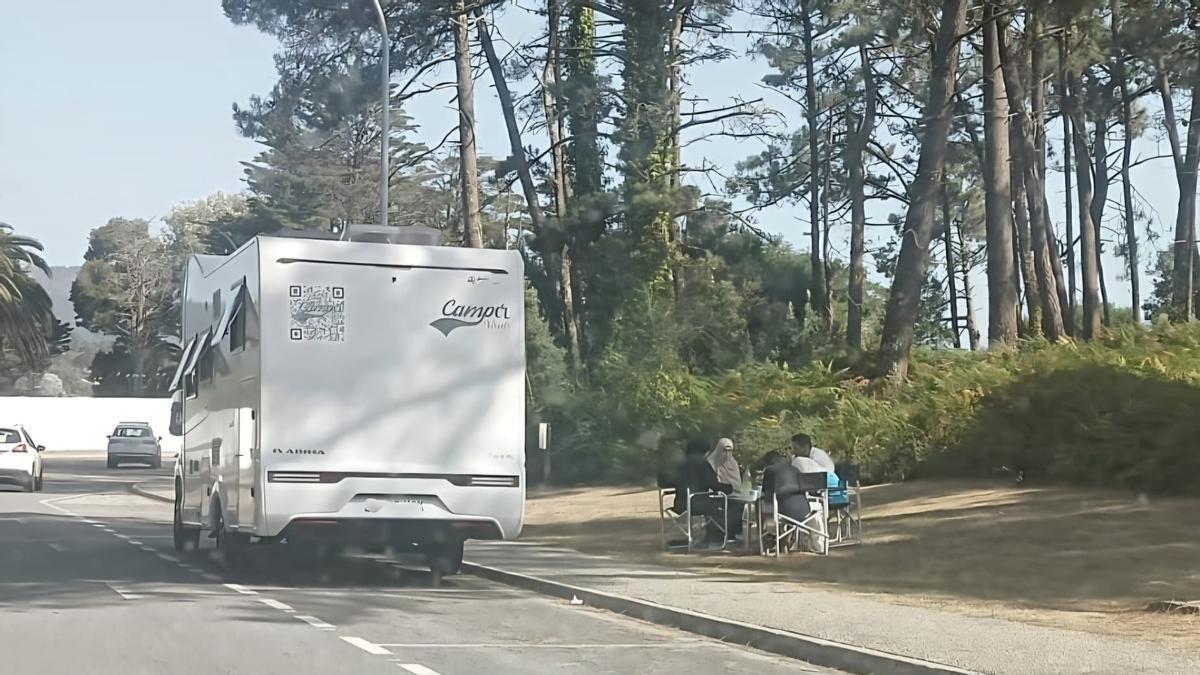 Usuarios de una autocaravana comiendo en el Monte Central de A Toxa, ante el Real Club de Golf La Toja.