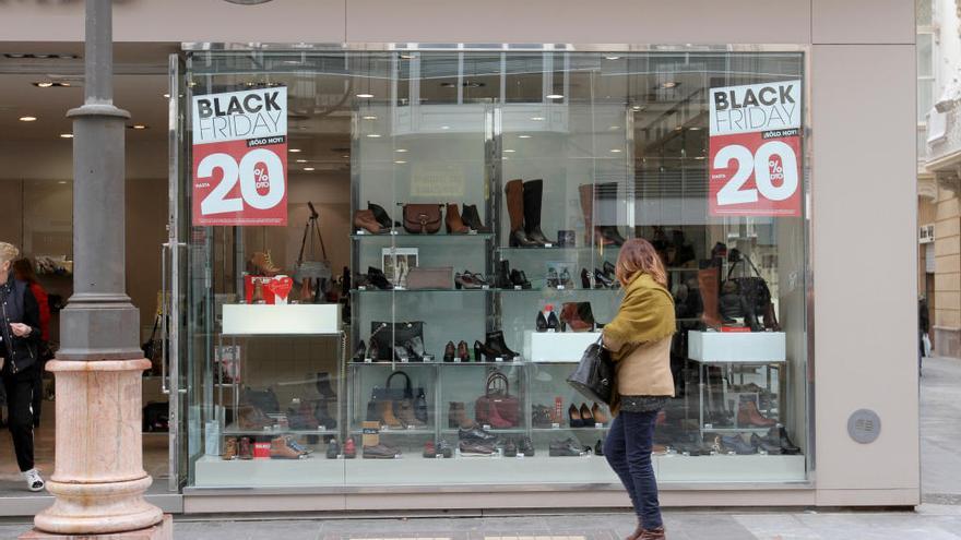 Una mujer pasa frente a un comercio con rebajas del ´Black Friday´ en Cartagena.