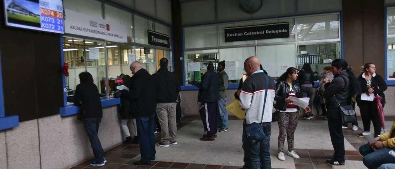 Un grupo de vecinos en la lonja del Concello, en Praza do Rei, espera su turno para realizar trámites municipales. // FdV