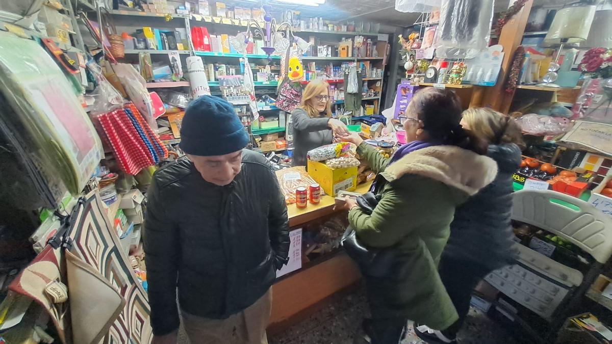 Cristina Menéndez, despachando a varios clientes en su tienda.