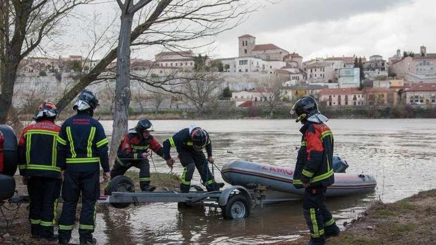 Los bomberos, con la zodiac, en el Duero.