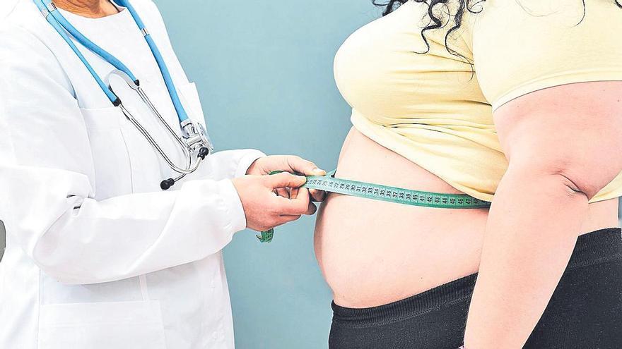 Unha médica mídelle o ventre a unha muller con exceso de peso