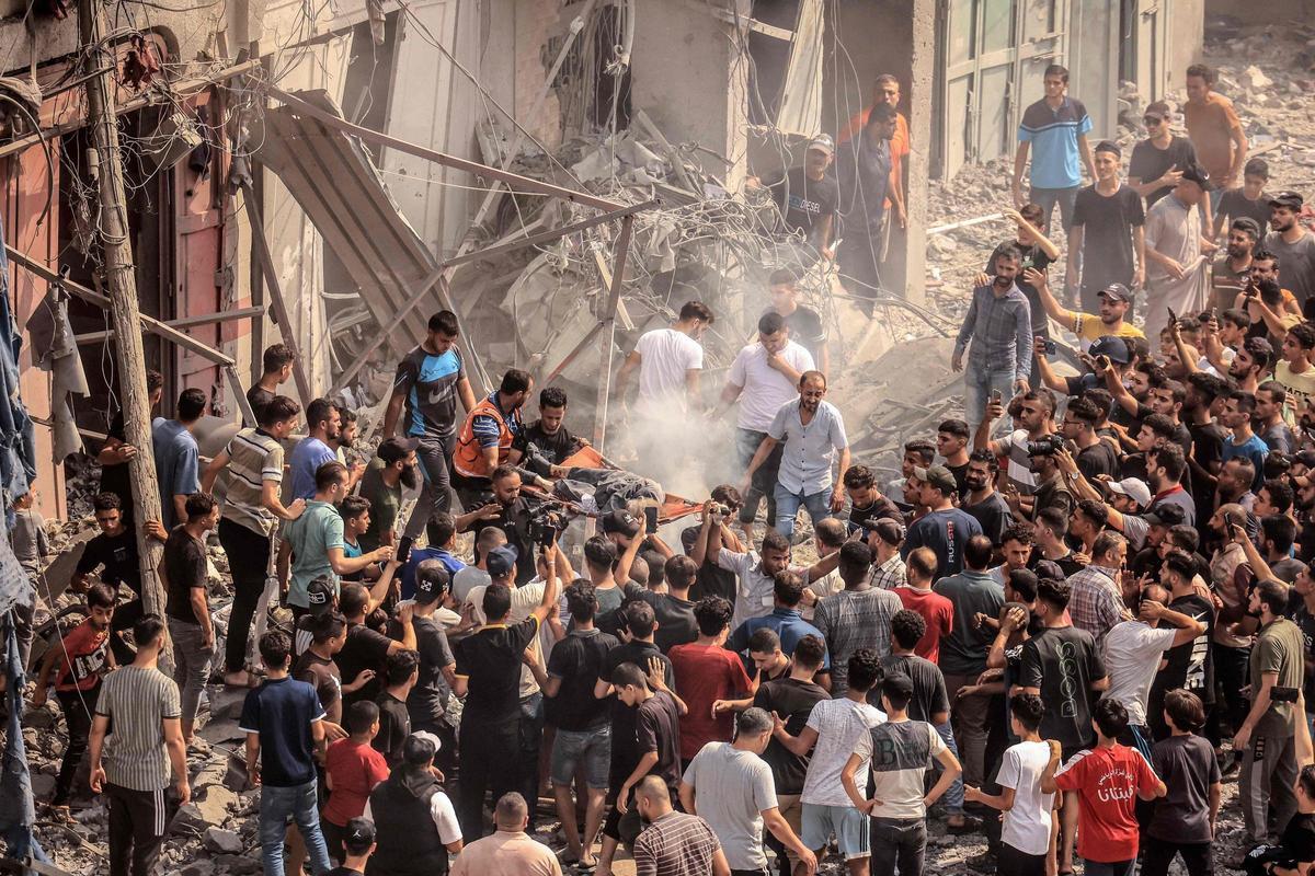 Palestinos evacúan cuerpos de los escombros tras un ataque aéreo israelí a la mezquita de Sousi, en la ciudad de Gaza.