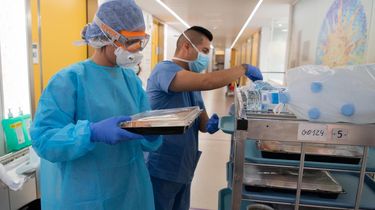 Professionals sanitaris entren el dinar a un malalt de coronavirus de l&#039;Hospital Clínic.