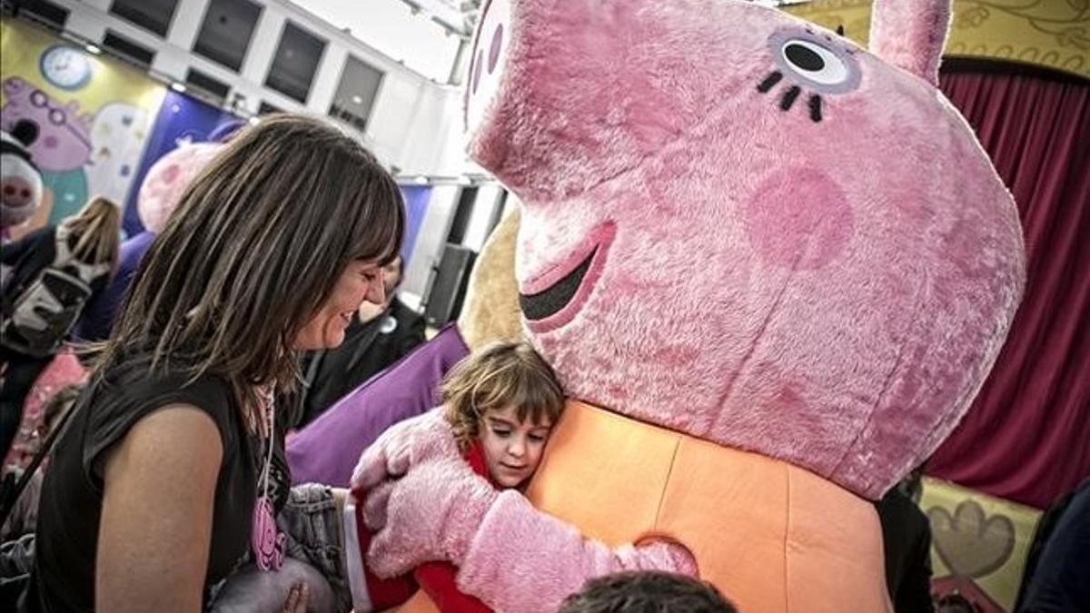 Una niña abraza a Peppa Pig ante la atenta mirada de mamá, en el Festival de la Infancia.
