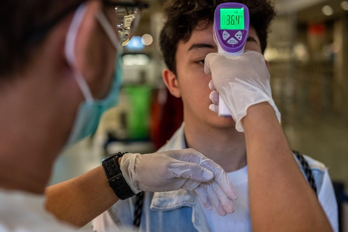 12 March 2020, Indonesia, South Tangerang: Medical team member checks body temperature amid the coronavirus outbreak. Photo: Donal Husni/ZUMA Wire/dpa