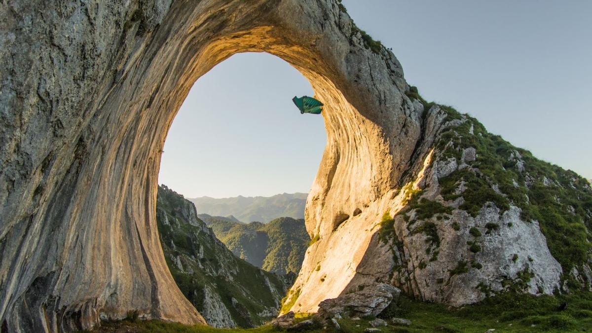 El "ojo de buey" de Peña Mea, en Asturias, siendo atravesado por Filip Kubica con su traje de alas