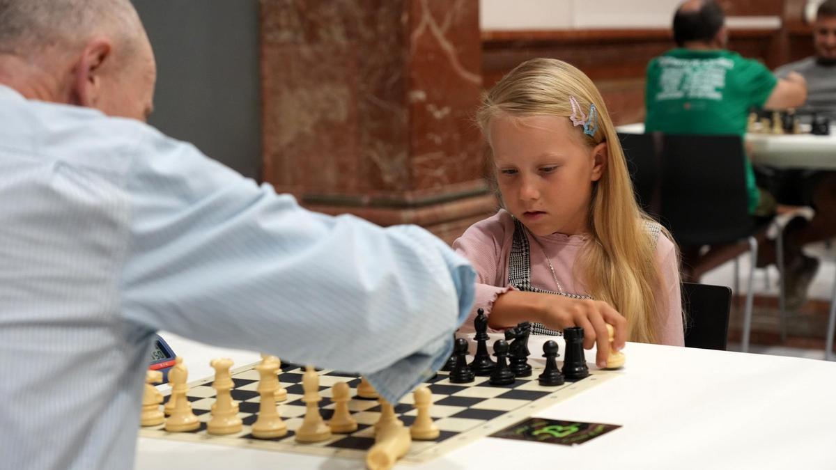 Una niña jugando al ajedrez con una persona mayor, en Castelló, en imagen de archivo.