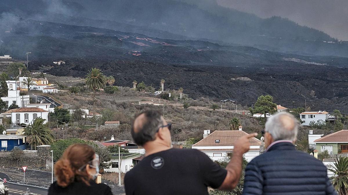 Tres personas observan la lava. |   // ÁNGELES MEDINA