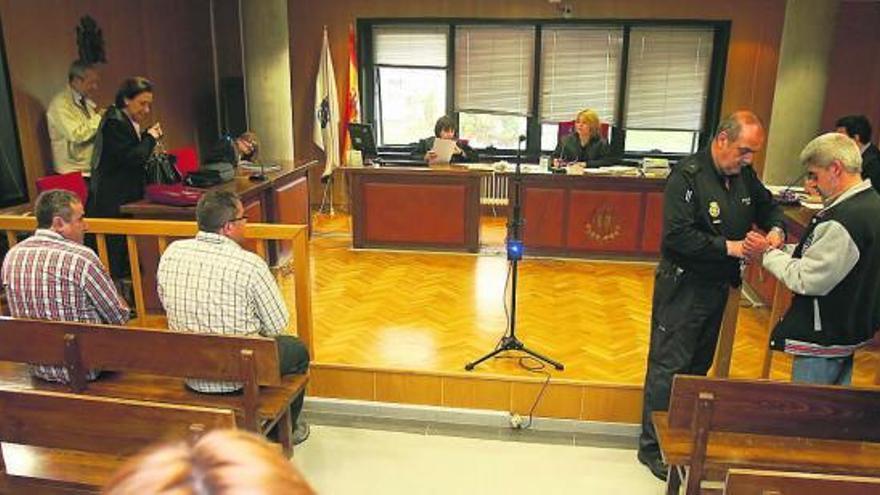 Los hermanos Costas, a la izquierda, observan la llegada de José Luis Mosquera, esposado. // Jesús de Arcos