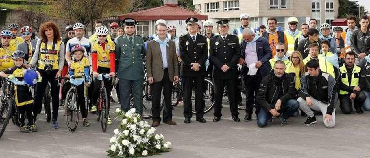 El alcalde junto a efectivos de la Policía Local y Guardia Civil y participantes en la marcha, durante el homenaje a las víctimas. // J. Lores