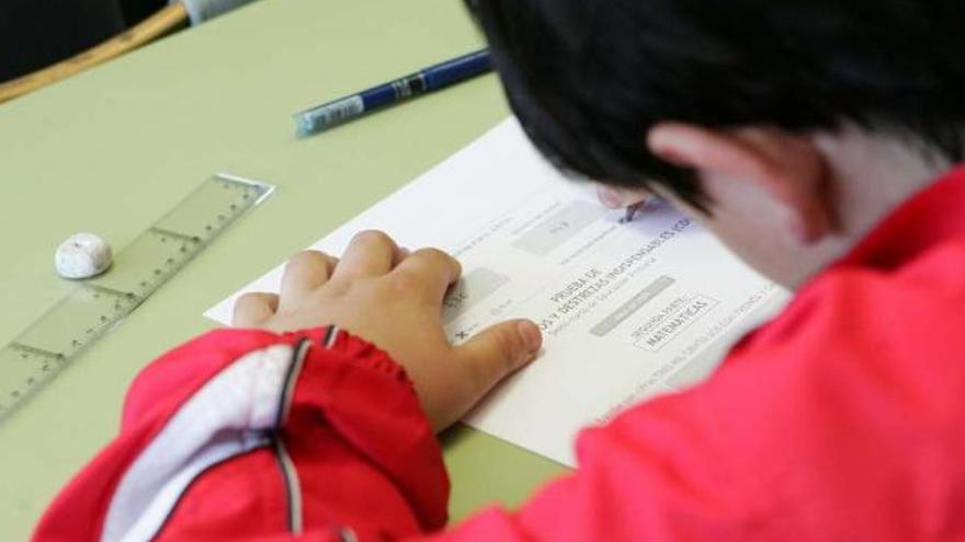 Un niño realiza un examen en su aula. / efe