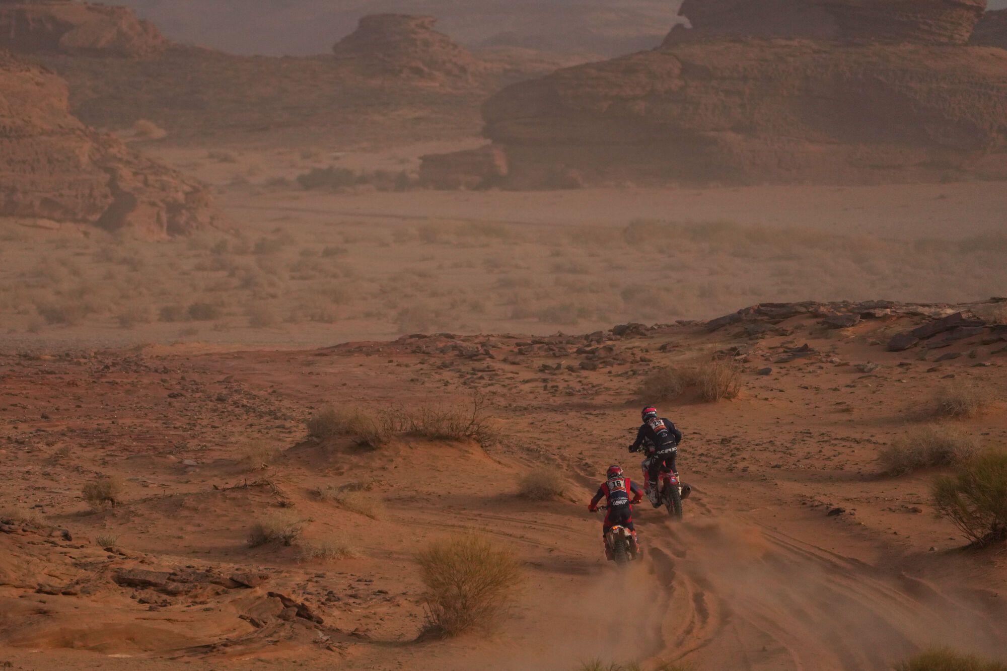 Riders Toni Mulec, left, and Paolo Lucci, right, compete during the third stage of the Dakar Rally with a start and finish in Alula, Saudi Arabia, Tuesday, Jan. 6, 2026. (AP Photo/Thibault Camus)