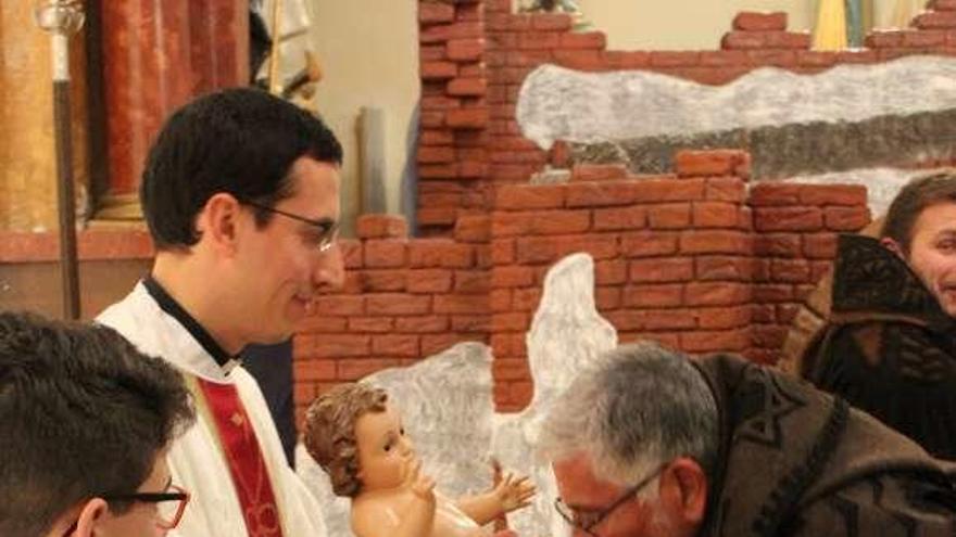 Un feligrés besando al niño en Tábara durante un acto religioso.