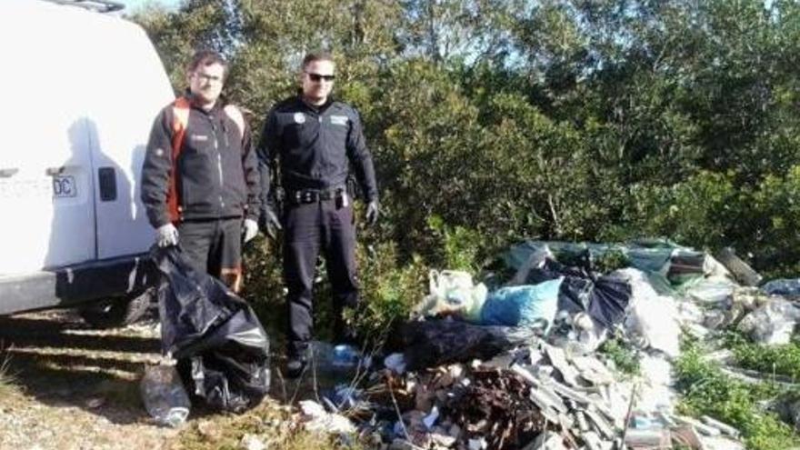 Ortspolizisten neben einer illegalen Mülldeponie.