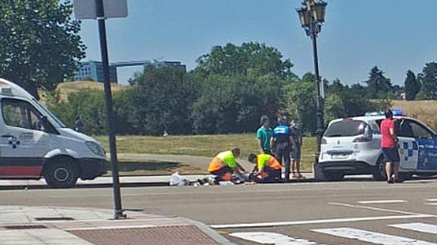 Sanitarios y policías auxiliando a la mujer herida en el mismo lugar del atropello.