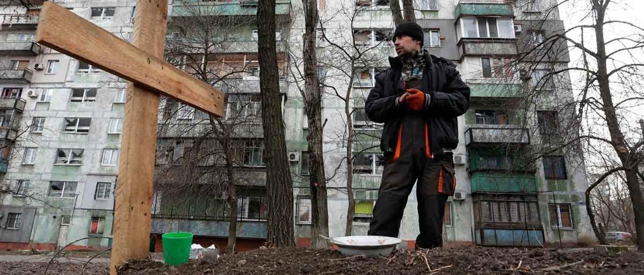 Un ciudadano de Mariúpol junto a la tumba de un amigo, muerto durante un ataque ruso en la localidad ucraniana.