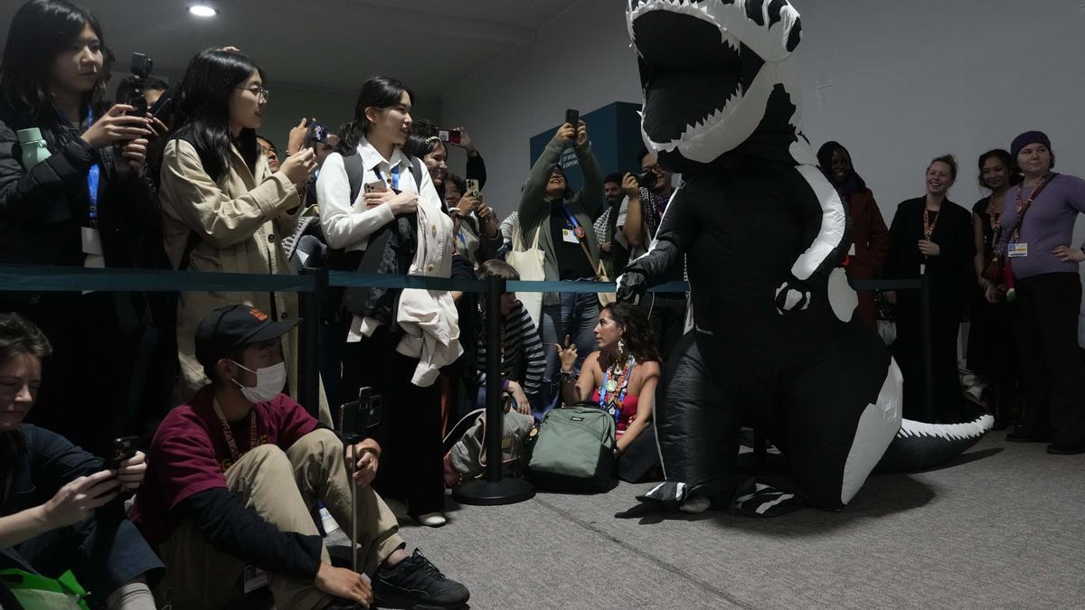 Un activista vestido de dinosaurio, afiliado a la plataforma 'Climate Action Network', protagoniza una protesta en la cumbre del clima de Bakú.