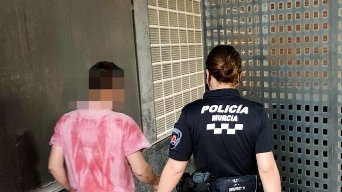 El detenido, custodiado por una agente.