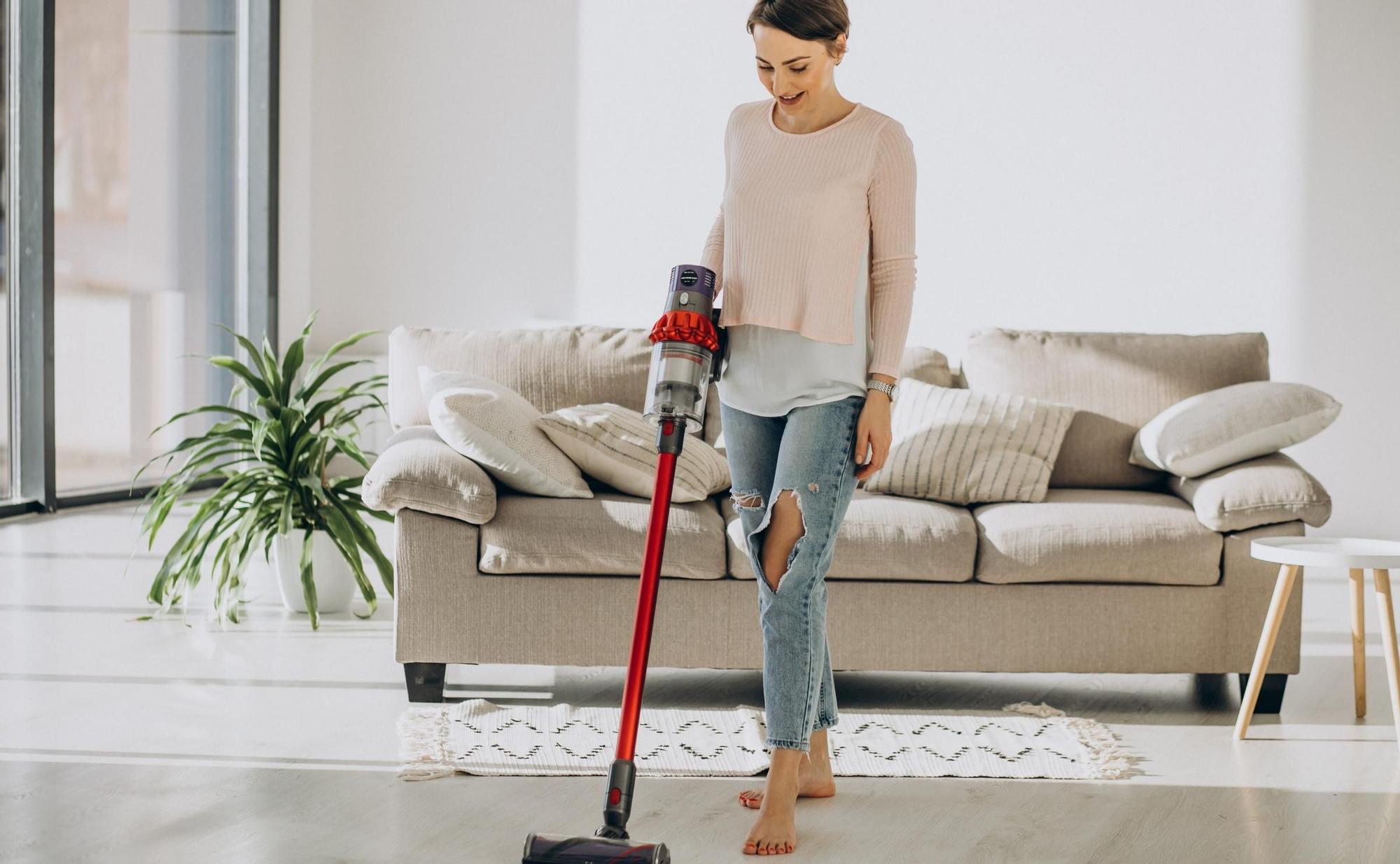 Una mujer pasa un aspirador Dyson  para una limpieza profunda y eficiente.