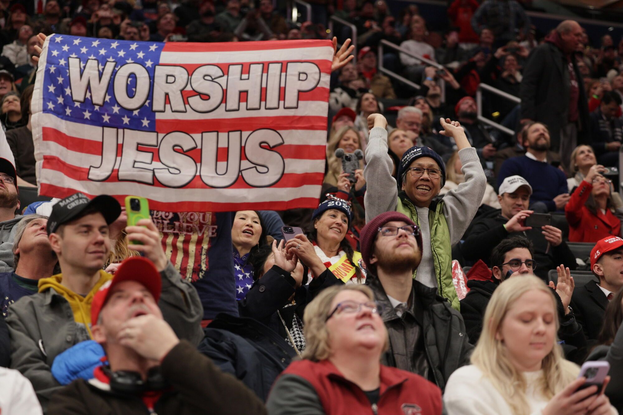 Washington (United States), 20/01/2025.- Guests hold a banner that reads 'Worship Jesus' as they watch the inauguration proceedings on a large screen at the Capitol One Arena during inauguration ceremonies for US President-elect Donald Trump in Washington, DC, USA, 20 January 2025. Trump is being sworn in on 20 January 2025 as the 47th president of the United States, though the planned outdoor ceremonies and events have been cancelled due to a forecast of extreme cold temperatures. (Estados Unidos) EFE/EPA/ALLISON DINNER