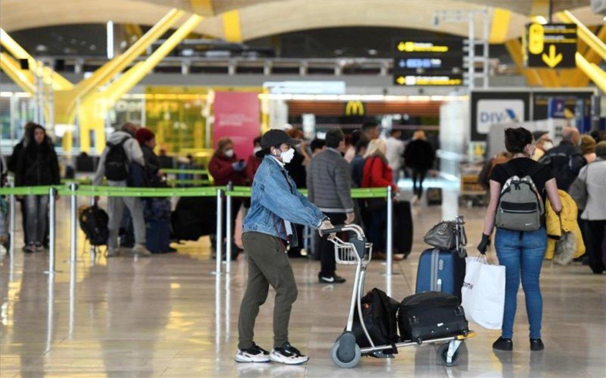 Pasajeros en un aeropuerto con mascarilla por el coronavirus. Pasajeros en un aeropuerto con mascarilla por el coronavirus.