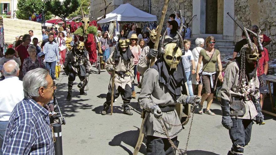 La colla de diablos &quot;Escarrufaferros&quot; desfilando por una calle próxima a la iglesia.