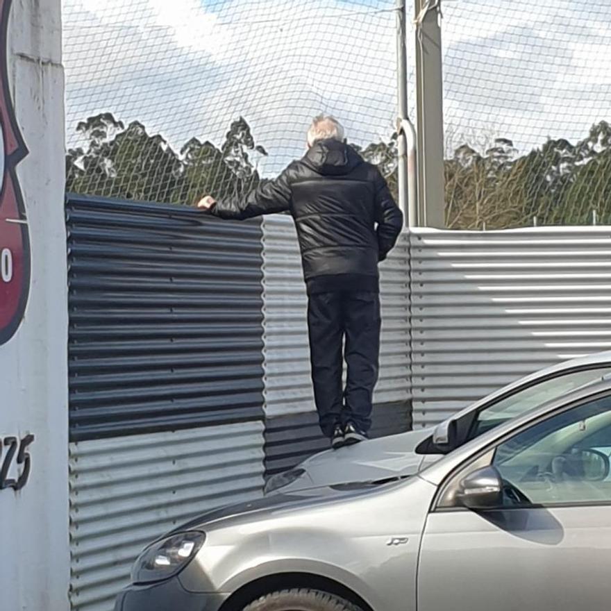 Víctor Lomba, viendo el partido del Estradense sobre su coche.