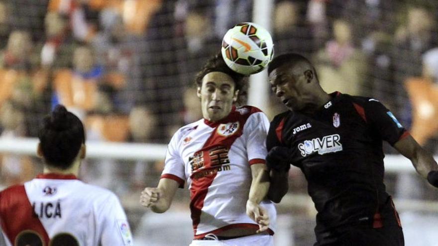 Baena (i) salta a por un balón con Córdoba (d), del Granada.