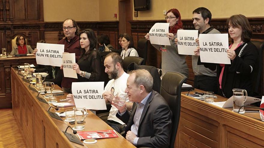 Los concejales de Xixón Sí Puede muestran carteles durante una sesión plenaria en Gijón.