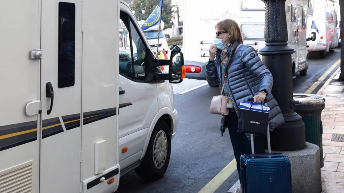 Una mujer, dialogando con un autocaravanista ayer en Oviedo. | L. Murias