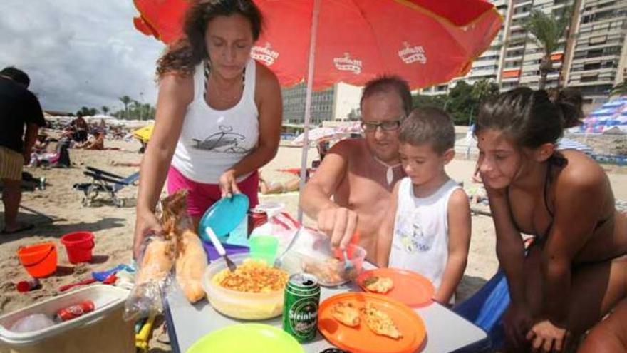 Una familia disfruta una comida en la playa.