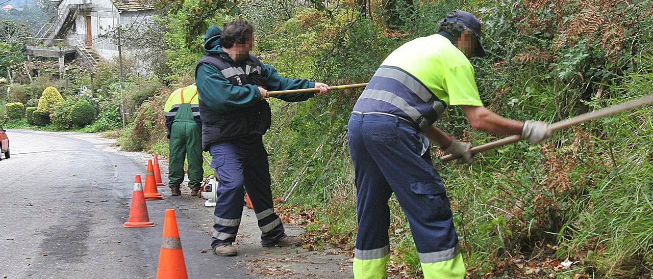 Foto de archivo en la que hay tres personas realizan trabajos en beneficio de la comunidad. |  // R.GROBAS