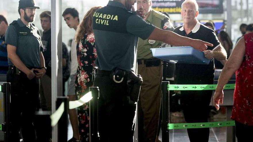 Agentes de la Guardia Civil, ayer, en los arcos de seguridad del aeropuerto de El Prat. // Efe