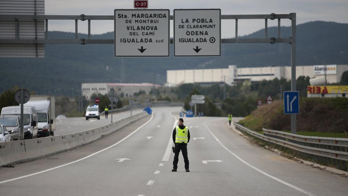 Un agente de los Mossos vigila el acceso a Igualada, confinada por el coronavirus.