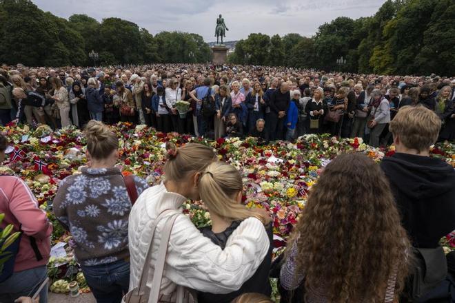 Una multitud de personas se reúnen en la Plaza del Palacio de Oslo con velas y flores tras la muerte del rey Harald.