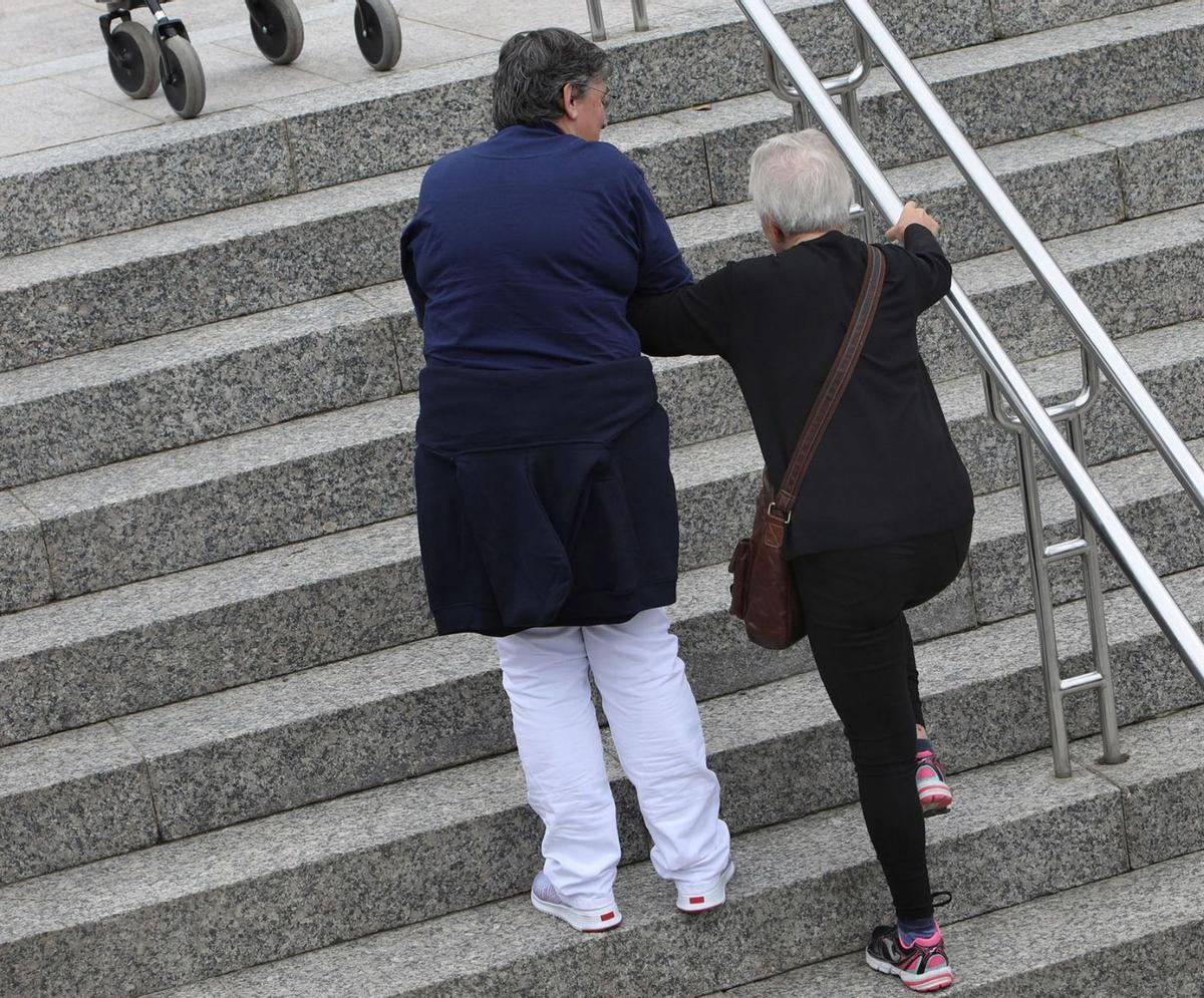 Una cuidadora ayuda a una anciana.