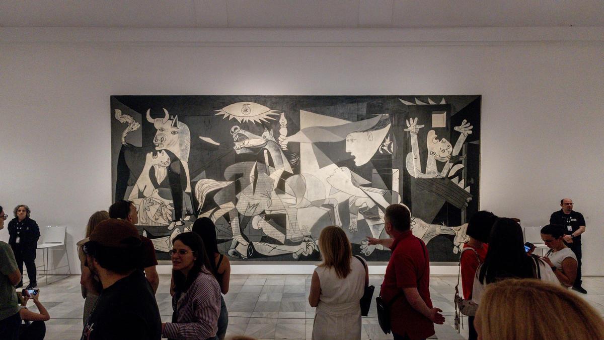 Archivo - Varias personas en el Museo Reina Sofía ante el Guernica