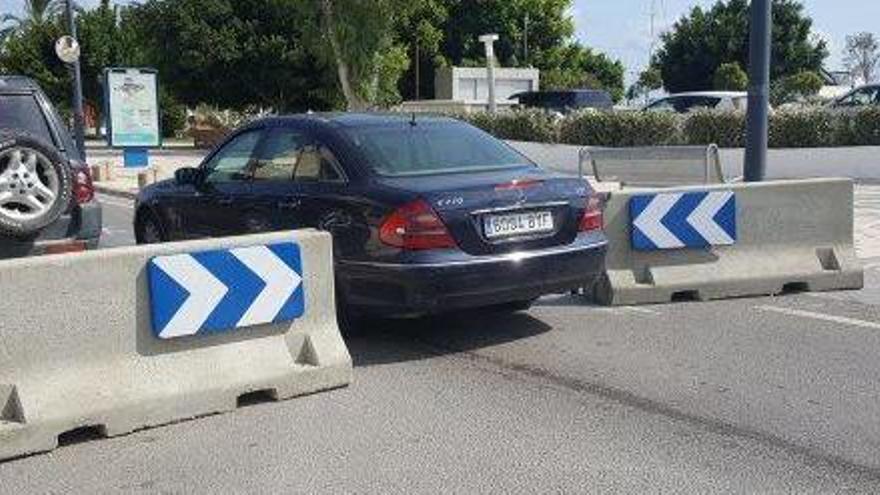 Un coche atraviesa el estrecho paso entre las dos barreras de hormigón.