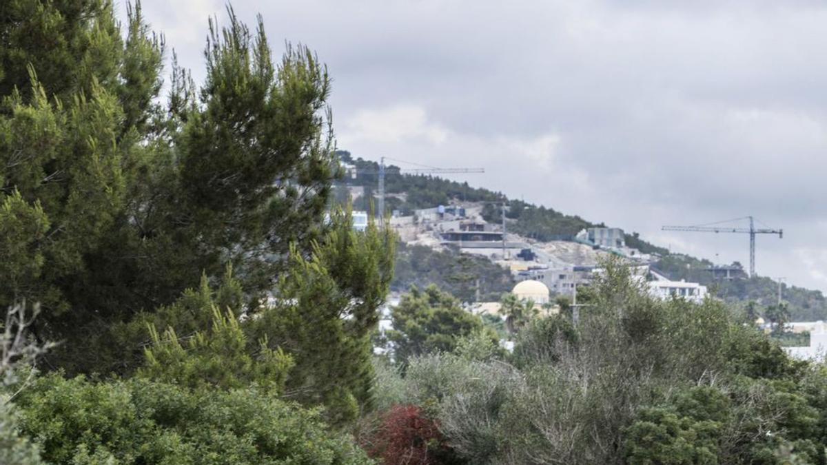 Ropa tendida en el campamento y, al fondo, las viviendas de lujo que se están construyendo en Cas Mut.