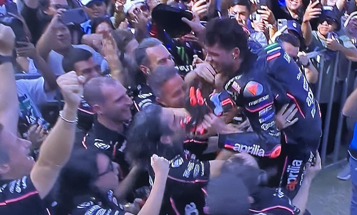 Marco Bezzecchi es felicitado, hoy, en Mandalika, por todo el equipo Aprilia.