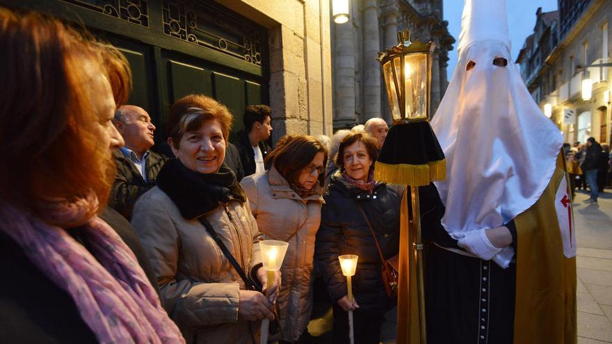 Cofrade del Silencio y fieles en la procesión del Nazareno. // G. Santos