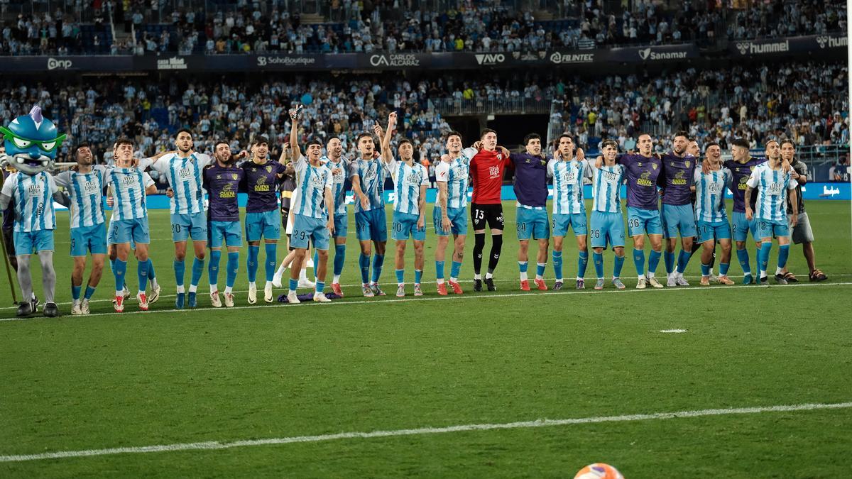 Los jugadores del Málaga CF celebran junto a la afición blanquiazul el triunfo del pasado sábado frente al Sporting de Gijón sobre el césped de La Rosaleda.