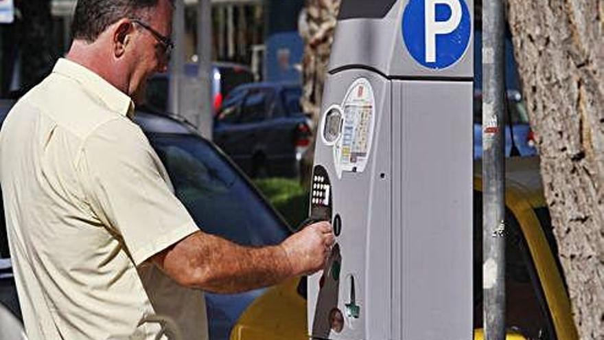 Un conductor saca un tique en un parquímetro de la ORA en Murcia.