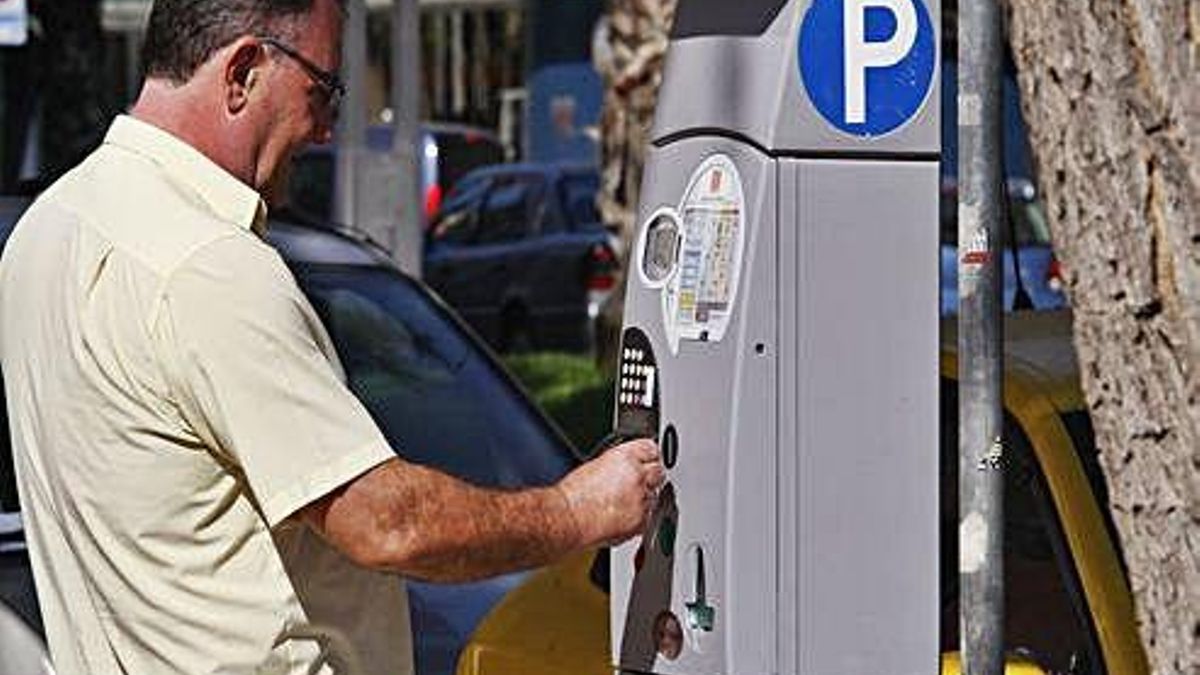Un conductor saca un tique en un parquímetro de la ORA en Murcia.