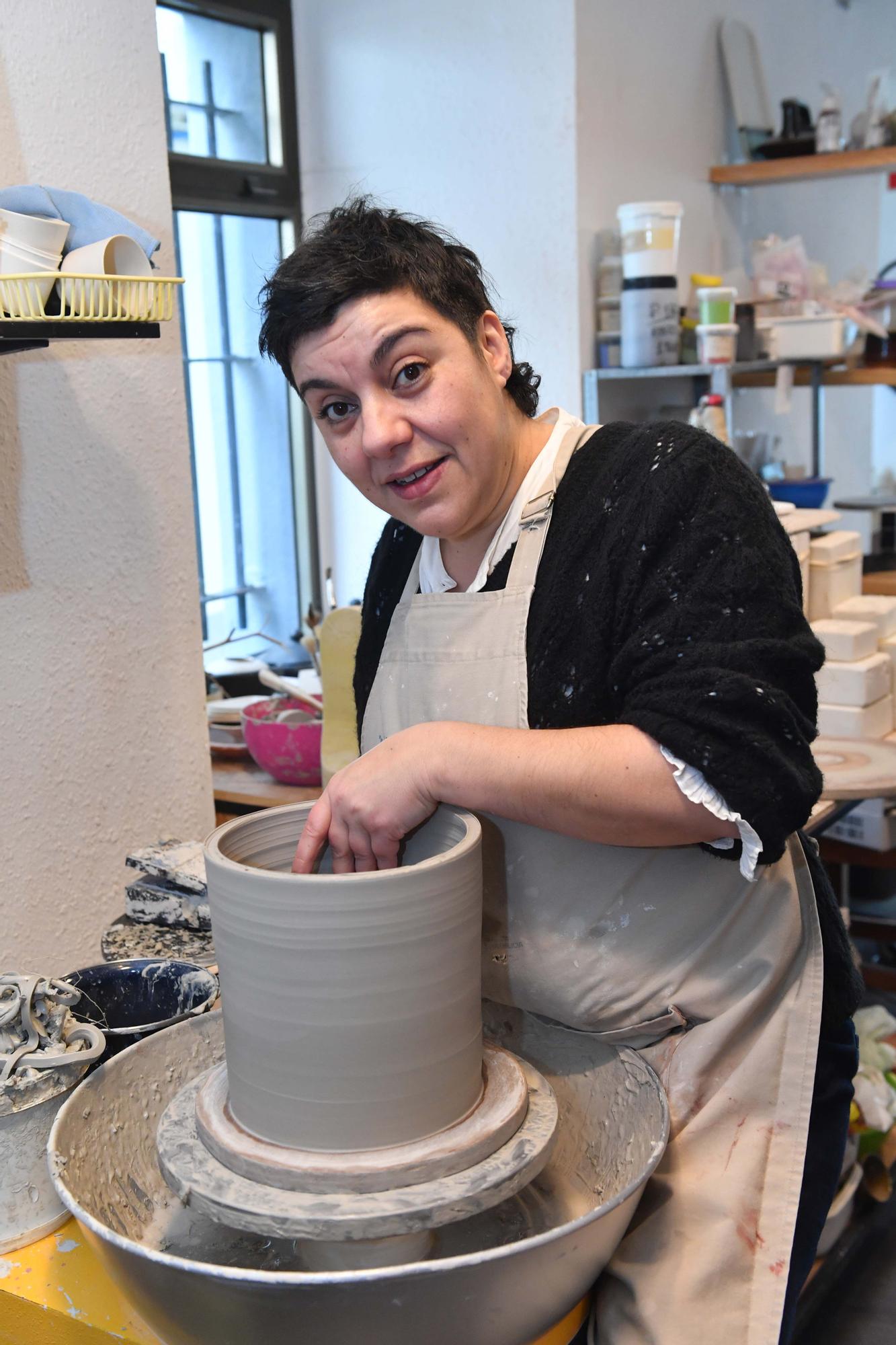 Laura Delgado con los vasos tiki ganadores, una combinación de culturas entre Polinesia y Galicia, y otras obras realizadas por esta ceramista en su taller de Cambre, en el que también da clases a pequeños grupos.