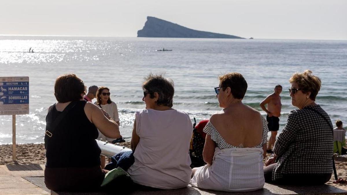 Varias mujeres charlan en un banco frente a la playa de Levante de Benidorm, estas Navidades.