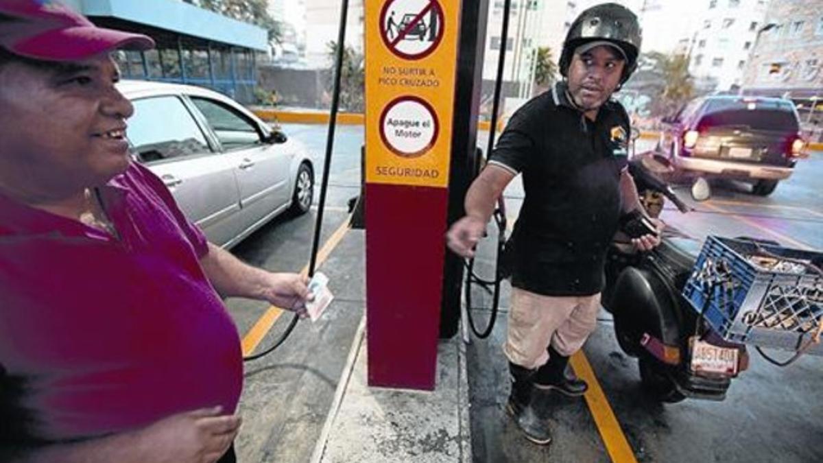 Un motorista paga, ayer, el combustible en una gasolinera de Caracas.