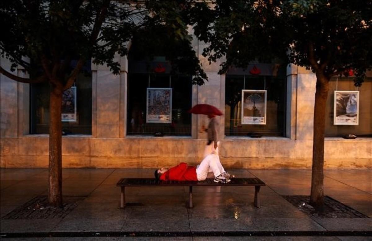 dcaminal34683327 a reveller sleeps on a public bench as it drizzles before th160713114438